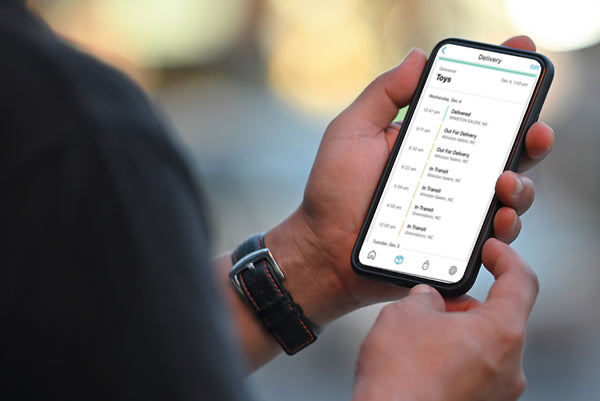 Hand holding a smartphone with a Loxx Boxx app interface.
