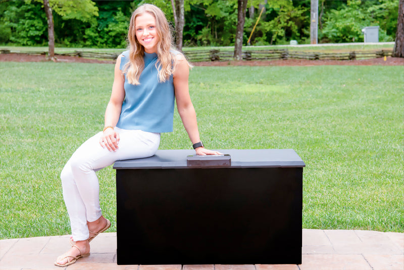 woman sitting on a strong durable loxx boxx which is a package delivery storage box with great security